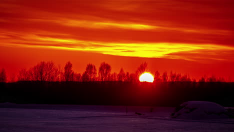 Glowing-orange-sunset-time-lapse-over-a-winter-landscape---zoomed-in-tight