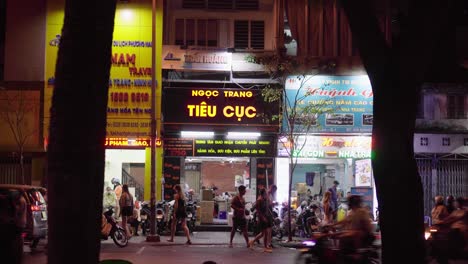 Actividad-De-Tráfico-Y-Peatones-Caminando-Por-Una-Carretera-Con-Comercios-Vietnamitas-En-El-Fondo-En-El-Distrito-1-De-La-Ciudad-De-Ho-Chi-Minh,-Vietnam