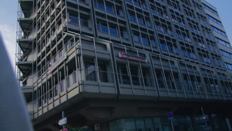 Corporate-Building-with-Car-Upwards-to-Low-Panning-Shot-Schlossplatz-In-Downtown-Stuttgart-in-4K,-Red-Komodo-Cooke-Mini-S4i-Lens-Premium-Quality-|-News