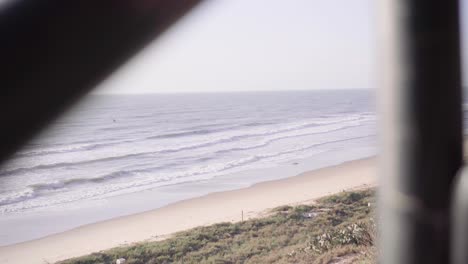 Vietnamesischer-Mann-Steigt-Aus-Einem-Auto,-Im-Hintergrund-Krachen-Die-Wellen-Am-Strand-Entlang-In-Mui-Ne,-Vietnam