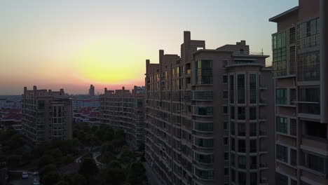Aerial-rises-above-apartment-buildings-on-sunrise-dawn-city-morning