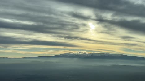 Dramatic-aerial-view-of-snowy-Mulacen-Peak-in-Sierra-Nevada,-Granada,-Spain,-in-a-cold-winter-mooring-after-sunrise