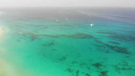 Aerial-View-Of-Two-Catamarans-Floating-In-Beautiful-Blue-Turquoise-Ocean-Waters-Off-Sal-Cape-Verde