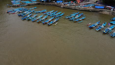 Drohnenaufnahme-Mit-Niedriger-Umlaufbahn-Von-Traditionellen-Indonesischen-Fischerbooten,-Die-Am-Hafen-Verankert-Sind---Baron-Beach,-Indonesien