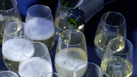 Gießen-Sie-Champagner-In-Champagnergläser-Zur-Vorbereitung-Einer-Feier-In-Zeitlupe,-Kreisende-Aufnahme