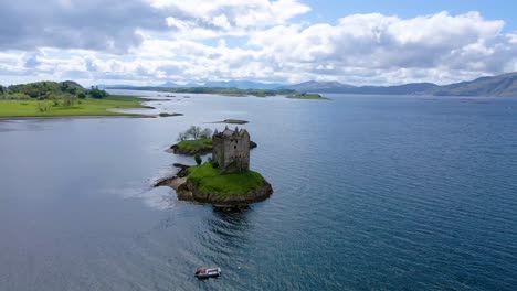 4k-aerial-drone-footage-of-castle-on-island-surrounded-by-open-water-in-scottish-highlands-scotland