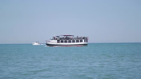 Menschen-Auf-Einem-Boot-Im-See,-Die-Am-Strand-Vorbeifahren