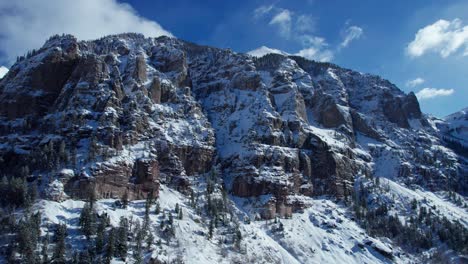 Drone-aerial-view-of-a-cliffside-in-Colorado-on-a-bright-sunny-day-with-snow