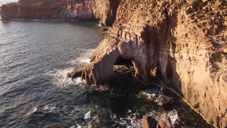 Astonishing-cliff-arched-cave-in-remote-coastline-in-Sardinia,-aerial-view