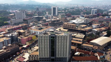 Aerial-view-tilting-away-from-the-Hotel-Adamaoua,-in-sunny-Yaounde-city,-Cameroon