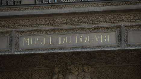 Signo-Del-Museo-Del-Louvre-En-París,-Tiro-Estático,-Gente-Caminando-Delante