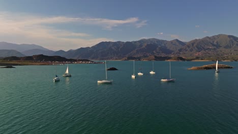Slow-establishing-shot-of-a-group-of-small-sailboats-anchored-off-the-coast-of-Mendoza