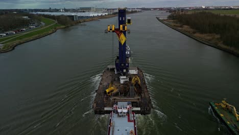 Towboat-pushing-a-raft-carrying-a-big-industrial-crane-over-water,-Ahoy,-Zwijndrecht