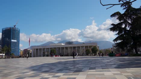 Main-square-of-city-paved-with-multicolored-marble-tiles-and-new-high-buildings-background-in-Tirana,-Albania