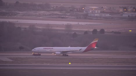 Vista-Lateral-Del-Vehículo-De-La-Grúa-Tira-Del-Avión-De-Iberia-En-El-Aeropuerto-De-Madrid