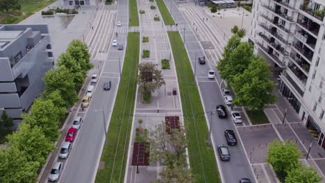 Aerial-view-of-Montpellier's-city-center-tramway-line,-surrounded-by-two-roads