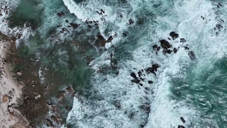 Top-down-drone-shot-ascending-off-Corny-Point's-rocky-beach-shores