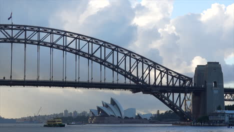 Un-Ferry-Pasa-Por-El-Puente-Del-Puerto-De-Sydney-Por-La-Mañana,-Australia