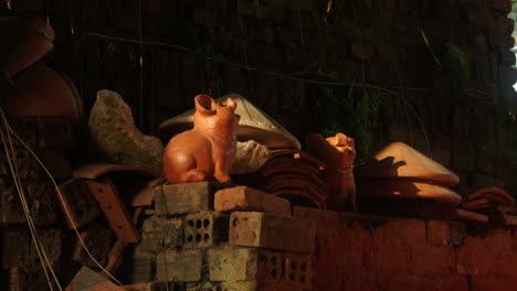 Chaos-and-creativity-reign-in-Thanh-Ha-pottery-village,-as-skilled-artisans-craft-traditional-pottery-while-two-red-clay-pigs-bask-in-the-sun