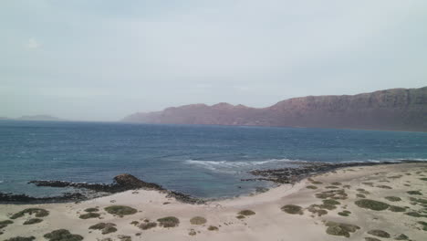 Playa-De-San-Juan-En-Lanzarote,-Montañas-Sobre-El-Mar