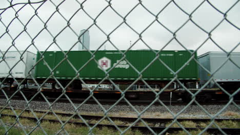 View-through-fence-of-Dallas,-Texas-and-railroad-train