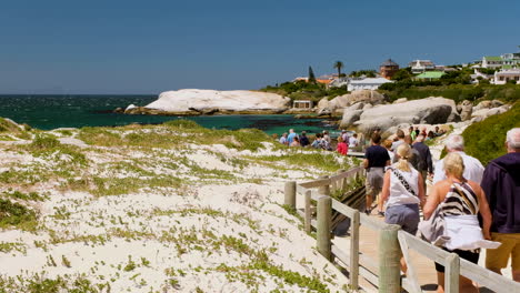 Touristen-Auf-Der-Strandpromenade-Mit-Felsbrocken-Bei-Extrem-Windigen-Bedingungen