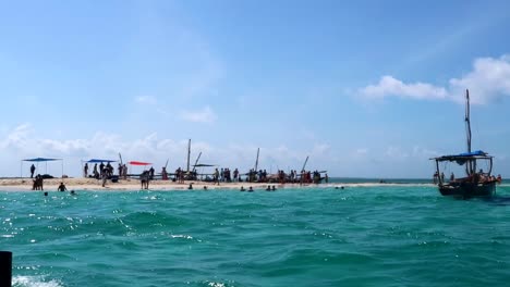Dolly-shot-of-crowded-sandbanks-and-traditional-wooden-boats-off-of-Kwale-Island