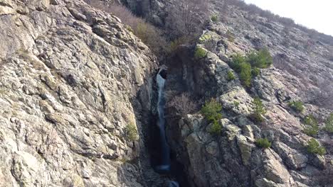 Drop-down-drone-footage-of-a-waterfall-in-the-Balkan-mountains-near-the-town-of-Sopot,-Bulgaria