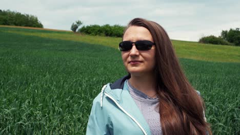 A-woman-with-sunglasses-near-a-field-of-oats