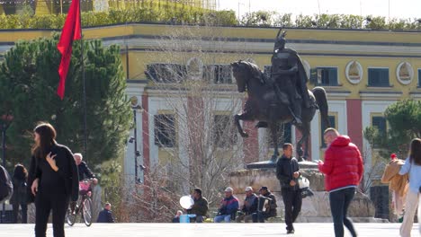 Skanderbeg-statue-on-main-square-of-Tirana-capital-city-in-Albania,-people-walking-on-street