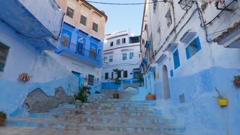 Man-walking-down-the-stairs-of-alleys-of-Chefchaouen-in-Morocco