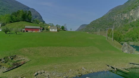 Häuser-Am-Grünen-Ufer-Des-Flusses-In-Der-Sommersaison,-Norwegen