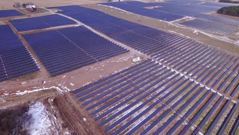 High-wide-aerial-pan-of-rows-of-panels-at-solar-power-farm-in-Michigan