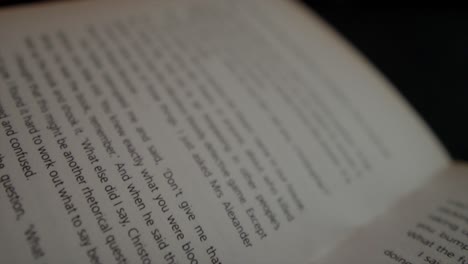 A-close-up-cinematic-shot-dollying-diagonally-across-the-printed-text-on-the-pages-of-an-interesting-novel-in-a-studio