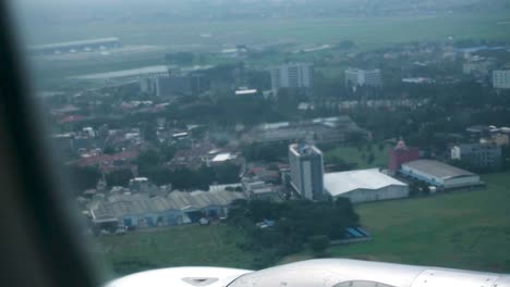 Handheld-shot-taken-from-the-window-of-a-landing-plane-with-a-view-of-the-cityscape