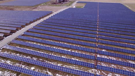 Panels-at-huge-American-solar-power-farm,-wide-panning-aerial-pull-out