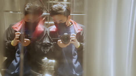 Chinese-model-filming-himself-with-professional-camera-in-to-the-mirror-wearing-respiratory-mask-for-smog-pollution