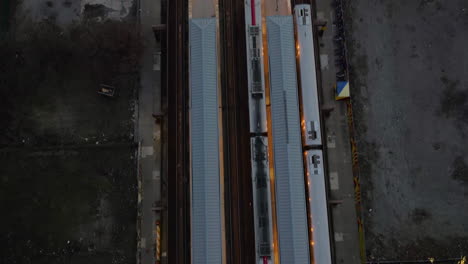 Aerial-view-above-trains-at-the-125th-Street-railway-station,-gloomy-evening-in-Harlem,-NY,-USA---top-down,-drone-shot
