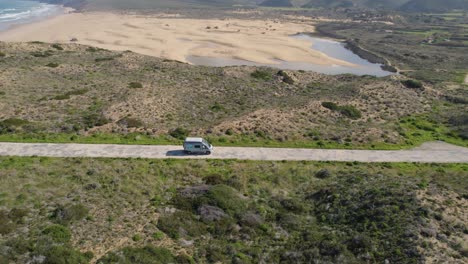Campervan-driving-along-small-road-following-the-Portuguese-coast-line-in-Europe