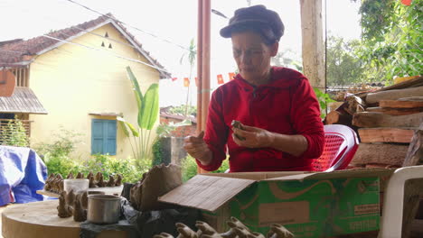 Una-Habilidosa-Mujer-Asiática-Fabrica-A-Mano-Una-Flauta-Tradicional-De-Arcilla-Con-Forma-De-Animal-En-Una-Tienda-De-Thanh-Ha,-Que-Exhibe-Recuerdos-Locales-Y-Turismo