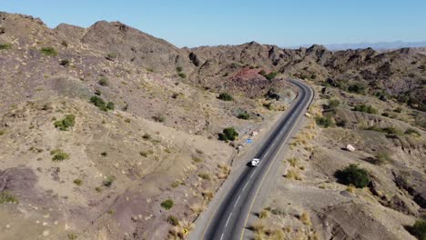 Aerial-View-Of-Vehicle-Driving-Along-Winding-RCD-Road-Through-Balochistan