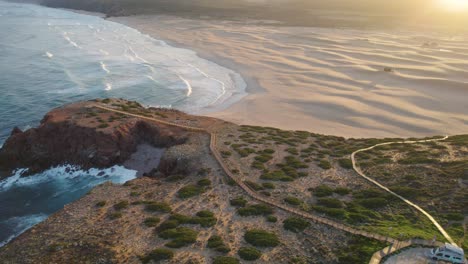 Aerial-establishing-at-sunrise-from-Praia-da-Bordeira-in-the-region-of-Algarve,-Portugal