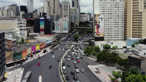 Aerial-view-over-traffic-on-Avenida-Prestes-Maia-in-Centro-Histórico-de-Sao-Paulo,-sunny-Brazil---reverse,-drone-shot