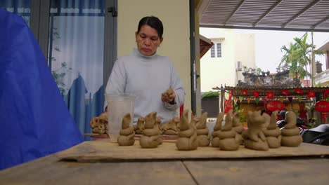 Una-Mujer-Thanh-Ha-Elabora-Figuras-De-Animales-De-Cerámica-Tradicional,-Mostrando-La-Cultura-Local-Y-Creando-Recuerdos-Turísticos