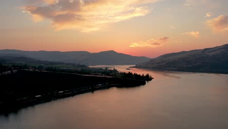 Der-Columbia-River-Bei-Sonnenuntergang-Mit-Einem-Daran-Entlangfahrenden-Zug