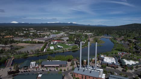 The-Old-Mill-in-Bend,-Oregon-with-Deschutes-River-and-Cascade-Mountains-in-the-distance