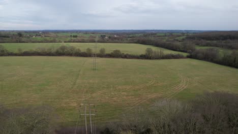 Nationale-Strommasten-In-Landwirtschaftlichen-Feldern,-Essex,-Vereinigtes-Königreich,-Drohnen-Luftaufnahme