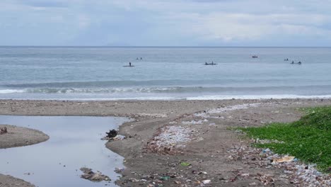 Lokale-Fischer-In-Kanubooten-überprüfen-Fischernetze-Entlang-Der-Küste-Mit-Angespülter-Meeresplastikverschmutzung-In-Der-Hauptstadt-Dili,-Timor-Leste,-Südostasien