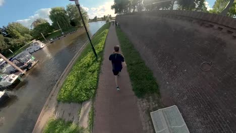 Time-lapse-of-immersive-swirling-camera-changing-angles-showing-a-male-trail-runner-along-boulevard-countenance-of-Dutch-city