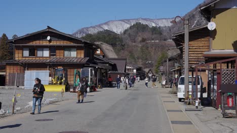 Tourists-Walk-Through-Shirakawago,-Historic-Village-in-Japanese-Alps